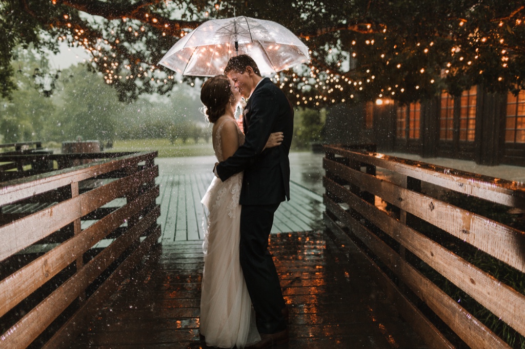 wedding couple kissing in the rain during their wedding